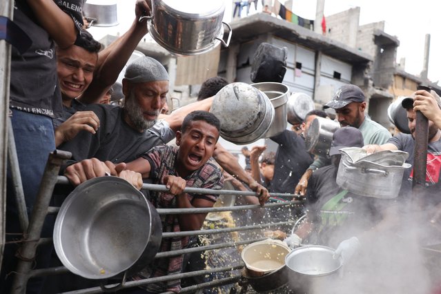Palestinians struggle to get their food rations ouside a crowded distribution centre in Beit Lahia in the northern Gaza Strip on May 15, 2025. Gaza rescuers said Israeli strikes and shelling on Thursday killed 82 people in the war-battered Palestinian territory, updating a previous toll. (Photo by Bashar Taleb/AFP Photo)
