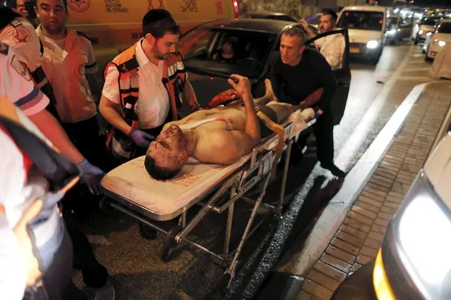 Israeli medics evacuate a Palestinian driver who was shot by Israeli soldiers at the Za'im checkpoint near the Israeli West Bank settlement of Maale Adumim, adjacent to Jerusalem October 7, 2015. Israel's prime minister canceled a visit to Germany on Wednesday after a spate of attacks that included the stabbing of an Israeli soldier by a suspected Palestinian militant who police said was then shot dead by special forces. (Photo by Ammar Awad/Reuters)