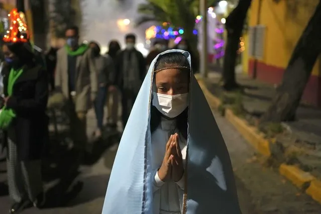 Residents participate in the procession of “Niñopan” during a Christmas “posada”, which means lodging or shelter, in the Xochimilco borough of Mexico City, Wednesday December 21, 2022. (Photo by Eduardo Verdugo/AP Photo)