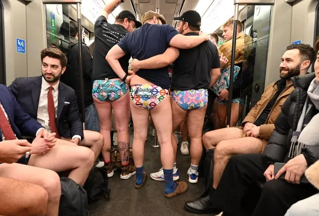 People take part in the annual “No Trousers On The Tube Day” (No Pants Subway Ride) on the London Underground in central London on January 8, 2023. 2023 sees the 12th annual No Trousers Tube Ride in London. The day is now marked in over 60 cities around the world. The idea behind “No Pants” is that random passengers board a subway car at separate stops in the middle of winter, without wearing trousers. (Photo by Justin Tallis/AFP Photo)