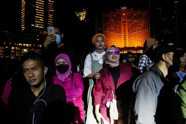 People stand at the Bundaran Hotel Indonesia roundabout where usually New Year's Eve is celebrated in Jakarta, Indonesia on  December 31, 2022. (Photo by Ajeng Dinar Ulfiana/Reuters)