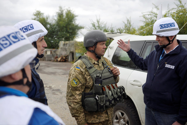 Members of the Organization for Security and Cooperation in Europe (OSCE) speak with a Ukrainian serviceman as they visit the town of Zolote in Luhansk region, September 26, 2016. (Photo by Maksim Levin/Reuters)
