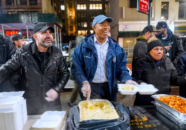 New York City Mayor Eric Adams (2nd R) together with “the pizza champion” Hakki Akdeniz (L), distribute food to New Yorkers in need at an event hosted by People Connecting New York (PCNY), The Ellen Maguire Foundation on January 25, 2023 in New York, United States. New York City Mayor Eric Adams' new weekly routine is to deliver food to the homeless every Wednesday at 9:00 PM in Midtown Manhattan. (Photo by Selcuk Acar/Anadolu Agency via Getty Images)