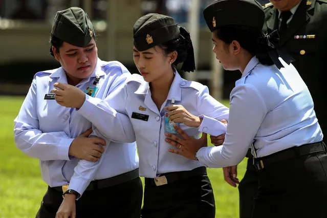 A member of the Royal Thai Army (C) is carried away after fainting during a handover ceremony for the new Royal Thai Army Chief at the Thai Army headquarters in Bangkok, Thailand, September 30, 2016. (Photo by Athit Perawongmetha/Reuters)