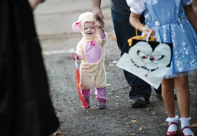 Laura Kienitz holds hands with her father Bobby Kienitz as they attend the Trunk or Treat at the Crown Health Services parking lot in Tyler, Texas on Thursday, October 29, 2015. Crown Health Services staff members decked out their cars with Halloween-inspired decorations and free candy for children. (Photo by Sarah A. Miller/Tyler Morning Telegraph via AP Photo)