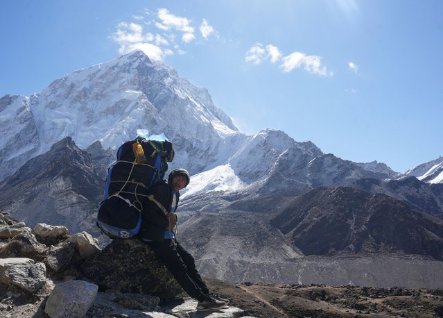 A porter takes a break while on his way to Everest base camp, at Lobuche in the Solukhumbu district, also known as the Everest region, Nepal on April 12, 2025. (Photo by Purnima Shrestha/Reuters)