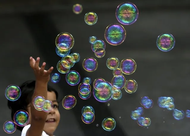 A migrant child plays with bubbles at Keleti railway station in Budapest, Hungary, September 6, 2015. (Photo by David W. Cerny/Reuters)