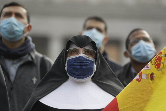 A nun wearing a face mask as she looks up at Pope Francis reciting the Angelus prayer from his studio window overlooking St.Peter's Square at the Vatican, Sunday, November 29, 2020. Pope Francis, joined by the church's newest cardinals at Mass, has warned against mediocrity as well as promoting one's career rise. (Photo by Gregorio Borgia/AP Photo)