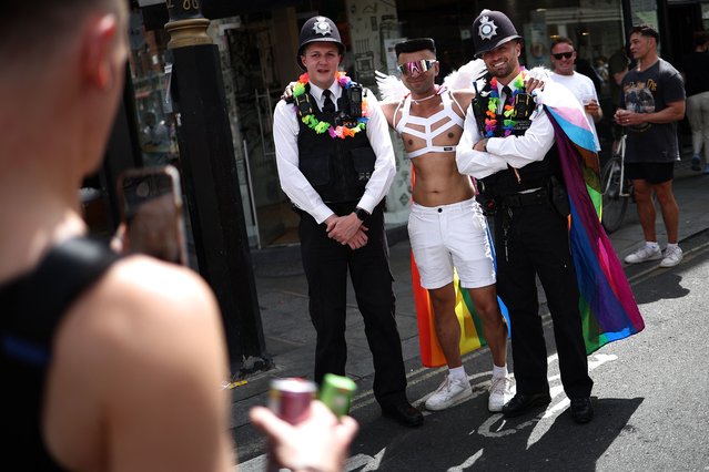 Metropolitan police officers pose for a photograph as people party in Soho following the of the annual Pride Parade, by members of the Lesbian, Gay, Bisexual and Transgender (LGBT+) community, in London on June 29, 2024. (Photo by Henry Nicholls/AFP Photo)