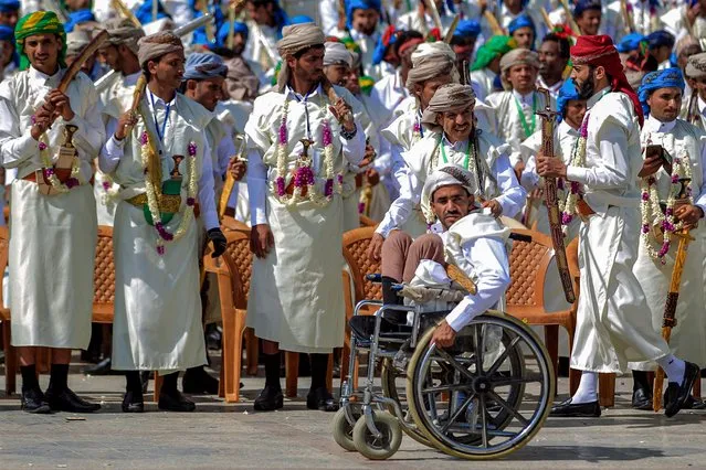 A wheelchair-bound disabled groom attends with other grooms dressed in traditional wedding attire a mass wedding for over four thousand couples organised by the Zakat authority under the control of Yemen's Huthi rebels in the Huthi-held capital Sanaa on October 31, 2022. (Photo by Mohammed Huwais/AFP Photo)