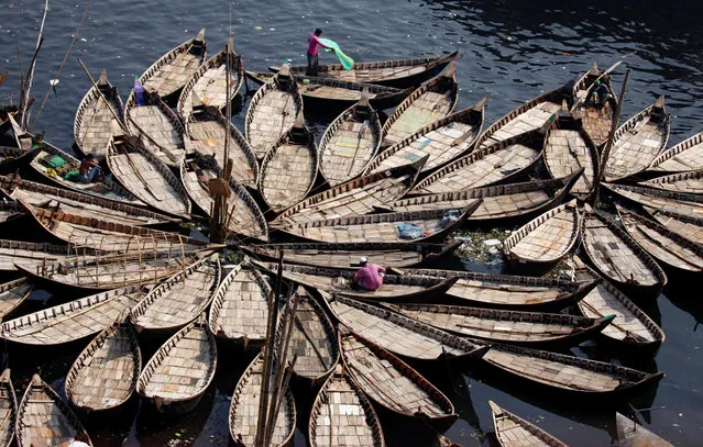 Bangladeshi people sit on anchored boats in the Buriganga River in Dhaka, Bangladesh, 16 April 2018. The Buriganga River is economically very important to Dhaka, used to transport a multitude of goods, produce and people everyday. It is estimated that some fifty thousand people cross the Buriganga River from Keraniganj to Dhaka, for work everyday. (Photo by Monirul Alam/EPA/EFE)