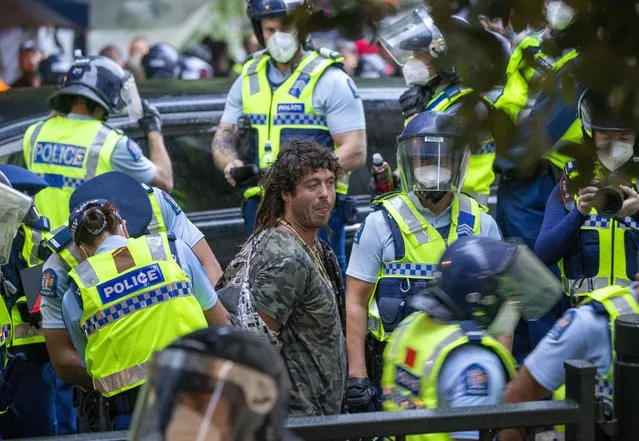 A demonstrator is arrested at a protest opposing coronavirus vaccine mandates in Wellington, New Zealand, Wednesday, March 2, 2022. Since the beginning of the pandemic, New Zealand has reported fewer than 100 virus deaths among its population of 5 million, after it imposed strict border controls and lockdowns to eliminate earlier outbreaks. (Photo by Mark Mitchell/New Zealand Herald via AP Photo)