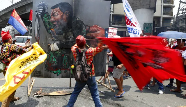 Protesters strike a painting depicting President Rodrigo Duterte as they mark the anniversary of the siege by Islamic State group-aligned militants of Marawi city in southern Philippines exactly a year ago Wednesday, May 23, 2018 in Manila, Philippines. The May 23 siege that troops crushed in October, killed more than 1,100 mostly militants, left the mosque-studded city's heartland in rubbles, gave President Rodrigo Duterte's his most serious crisis and reinforced Asian fears that the Islamic State group has gained a foothold in the region. (Photo by Bullit Marquez/AP Photo)