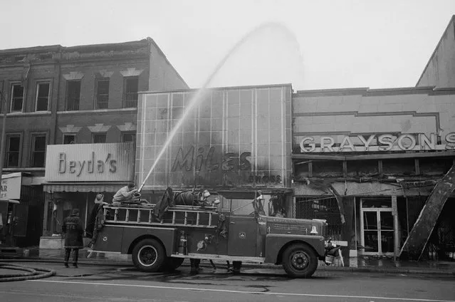 Firefighters spraying water on shops, including Beyda's, Miles Shoes, and Graysons, that were burned during the riots that followed the assassination of Martin Luther King, Jr., April 1968. (Photo by Reuters/Library of Congress)