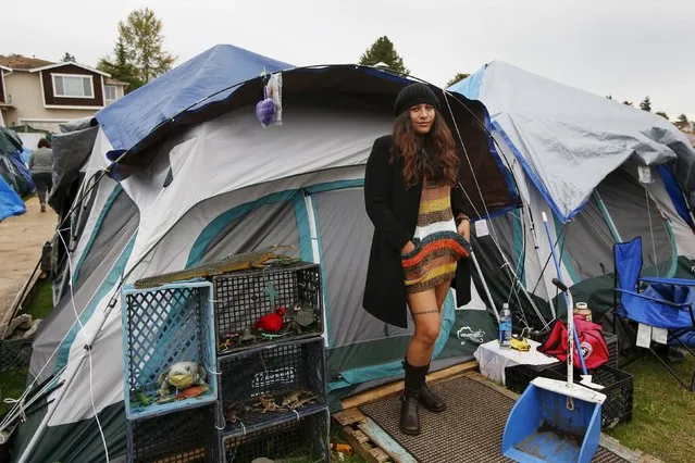Kalaniopua Young, 32, originally from Hawaii, poses outside her tent at SHARE/WHEEL Tent City 3 outside Seattle, Washington October 12, 2015. “This is a choice I made to live here. I was lonely and depressed living in an apartment. I feel much better here with the social interaction and friendships. There is a direct democracy here with immediate results that differ from traditional bureaucracy”. (Photo by Shannon Stapleton/Reuters)