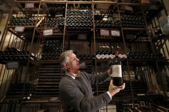 Remi Edange, manager at Domaine de Chevalier, presents a bottle of red wine in the cellar of Chateau Domaine de Chevalier (Graves Pessac Leognan label) in Leognan, near Bordeaux, southwestern France, February 10, 2015. The French Federation of Wine and Spirits Exporters (FEVS) will present the 2014 French wine and spirits annual exports during a news conference on Wednesday. (Photo by Regis Duvignau/Reuters)