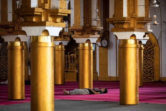 A Filipino Muslim man takes a nap after attending prayers on the first day of Ramadan at Golden Mosque in Quiapo, Manila, Philippines, April 13, 2021. (Photo by Eloisa Lopez/Reuters)