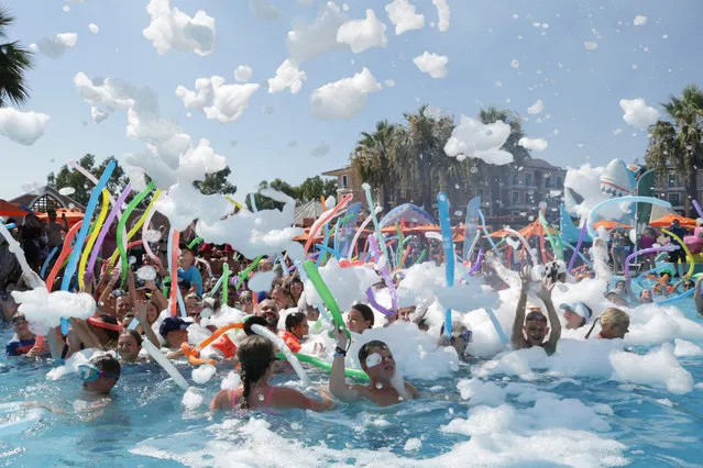 People swim in pool as the hotel offers ice blocks for tourists, cooling them off, during extreme hot weather in Antalya, Turkiye on August 09, 2023. The hotel provides service of ice fruits and foam party to its customers for them to relieve from heatwave. (Photo by Orhan Cicek/Anadolu Agency via Getty Images)