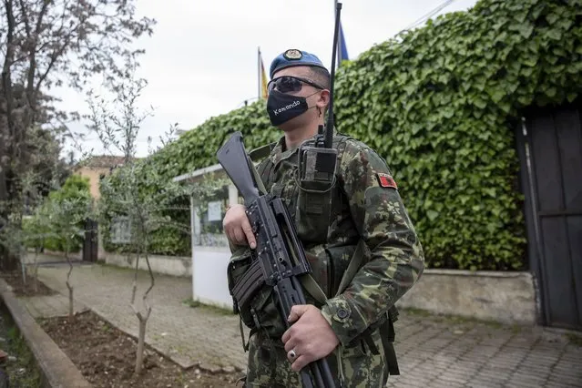 A member of the Albanian army secures the Spanish embassy ahead of the general elections in Tirana, Saturday, April 24, 2021. Albania holds parliamentary elections on Sunday amid the virus pandemic and a bitter political rivalry between the country's two largest political parties but that will serve as a key milestone in the country's next step toward European Union membership. (Photo by Visar Kryeziu/AP Photo)