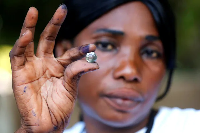 A poll worker holds a marble which represents one vote after the close of voting during the presidential election in Banjul, Gambia, December 1, 2016. (Photo by Thierry Gouegnon/Reuters)