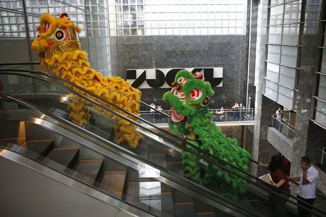 Lion dance performers ride on an escalator to perform at the trading floor of the Philippine Stock Exchange on the eve of Chinese New Year at Manila's Makati financial district February 18, 2015. (Photo by Erik De Castro/Reuters)