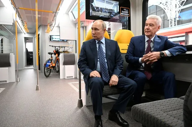 In this pool photograph distributed by Sputnik agency, Russia's President Vladimir Putin (L) and Moscow's mayor Sergey Sobyanin (R) sit in a train as they attend a ceremony to launch the Line D3 of the Moscow Central Diametres (MCD) suburban railway network in Moscow on August 17, 2023. (Photo by Kristina Kormilitsyna/Pool via AFP Photo)