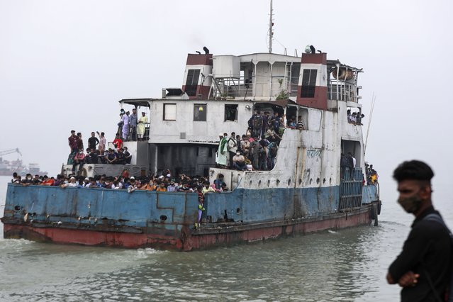 Thousands of people leaving for their native places to celebrate Eid-al-Fitr crowd a ferry at the Mawa terminal ignoring risks of coronavirus infection in Munshiganj, Bangladesh, Thursday, May 13, 2021. (Photo by Mahmud Hossain Opu/AP Photo)