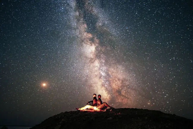 Stunning photos show couples silhouetted against night sky. (Photo by Andrei Sheliakin/Caters News Agency)