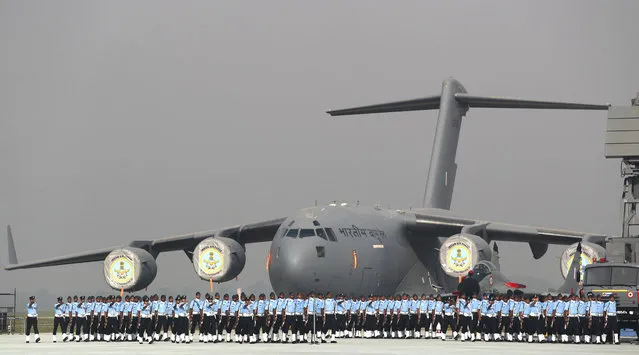 In this October 8, 2018, photo, Indian Air Force soldiers march past their C-17 Globemaster military transport aircraft during the Indian Air Force day parade at the Hindon air base on the outskirts of New Delhi, India. Air Force Day is celebrated to mark the day the Indian air force was officially established in 1932. Apart from defending Indian air space, the air force also delivers humanitarian aid and disaster relief material during natural calamities. (Photo by Manish Swarup/AP Photo)