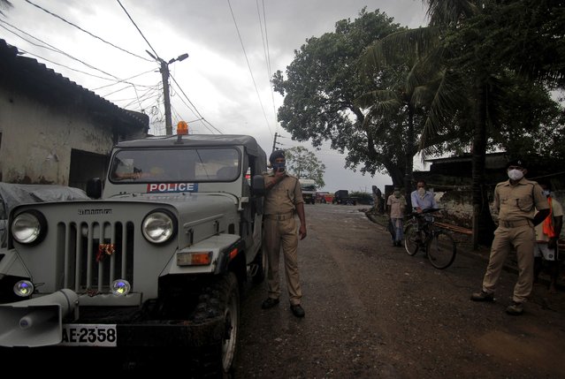 A policeman uses a loudspeaker asking residents of a village to move to cyclone shelters in Balasore district in Odisha, India, Tuesday, May 25, 2021. Tens of thousands of people were evacuated Tuesday in low-lying areas of two Indian states and moved to cyclone shelters to escape a powerful storm barreling toward the eastern coast. (Photo by AP Photo/Stringer)