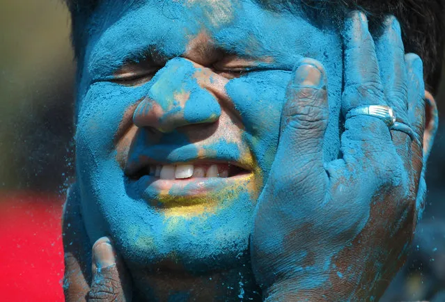 An Indian man closes his eyes as colored powder is smeared on his face during Holi festivities in Ahmadabad, India, Friday, March 6, 2015. Holi, India's joyful and colorful celebration of the arrival of spring along with several religious myths and legends, has long ago ceased to be only a Hindu festival. The streets and lanes across most of India turn into a large playground where people off all faiths throw colored powder and water at each other. (AP Photo/Ajit Solanki)