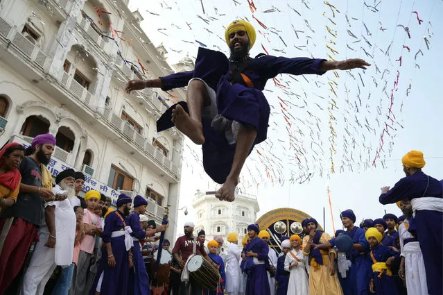 A Sikh man performs the Sikh martial art known as “Gatka” during a religious procession from Gurudwara Ramsar to Akal Takht Sahib at the Golden Temple in Amritsar on September 16, 2023, on the occasion of the 419th anniversary of the installation of the “Guru Granth Sahib” Sikh holy book. (Photo by Narinder Nanu/AFP Photo)