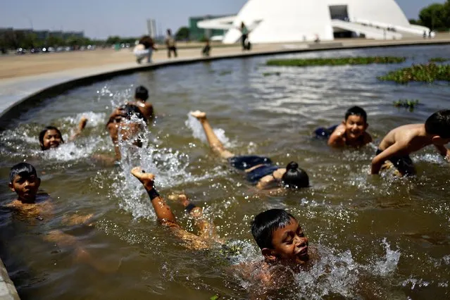 Brazilian Kayapo Indigenous children play in a water mirror, before a session to discuss the so-called legal thesis of “Marco Temporal” (Temporal Milestone) in Brasilia, Brazil on September 20, 2023. (Photo by Ueslei Marcelino/Reuters)