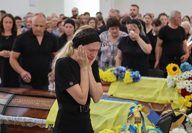 A woman reacts during a funeral ceremony for Maksym Rudenok, Serhii Batiuk, Ihor Khodak, Ukrainian service members, who were recently killed in fights against Russian troops, as their attack on Ukraine continues, in Ivano-Frankivsk, Ukraine on July 4, 2022. (Photo by Yuriy Rylchuk/Reuters)