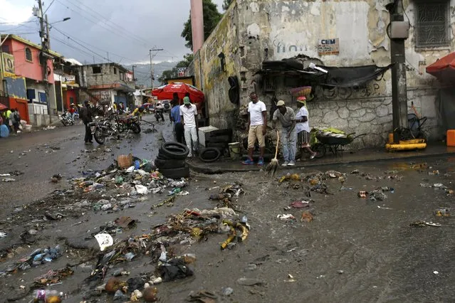 Debris litters a street caused by a flood of water brought on by heavy rains that fell over Port-au-Prince, Haiti, Friday, July 9, 2021, two days after Haitian President Jovenel Moise was assassinated in his home. (Photo by Fernando Llano/AP Photo)