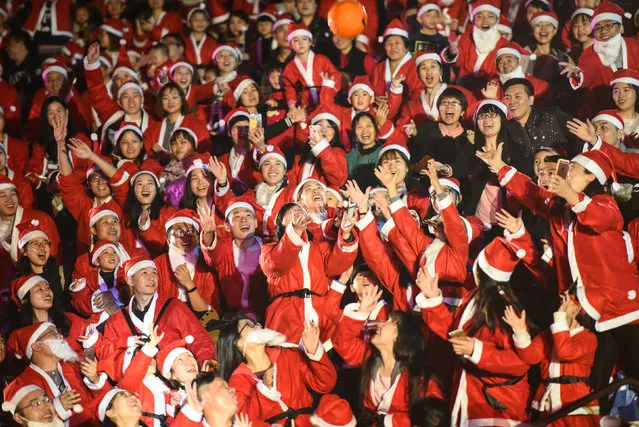 People wearing Santa Claus' costumes play a game as they celebrate the Christmas Eve in Shenzhen, Guangdong province, China, December 24, 2016. (Photo by Reuters/Stringer)