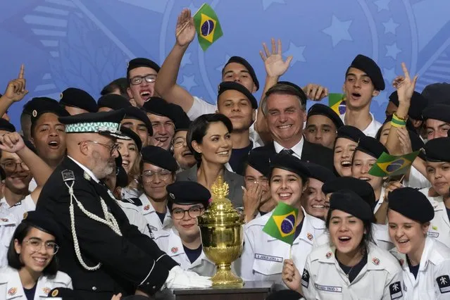 Brazil's President Jair Bolsonaro and his wife Michelle Bolsonaro, center, pose for photos with military cadets, next to the reliquary containing the heart of Brazil's former emperor Dom Pedro I, during a ceremony at the Planalto Presidential Palace in Brasilia, Brazil, Tuesday, August 23, 2022. The heart arrived for display during the celebrations of Brazil's independence bicentennial on Sept. 7. (Photo by Eraldo Peres/AP Photo)