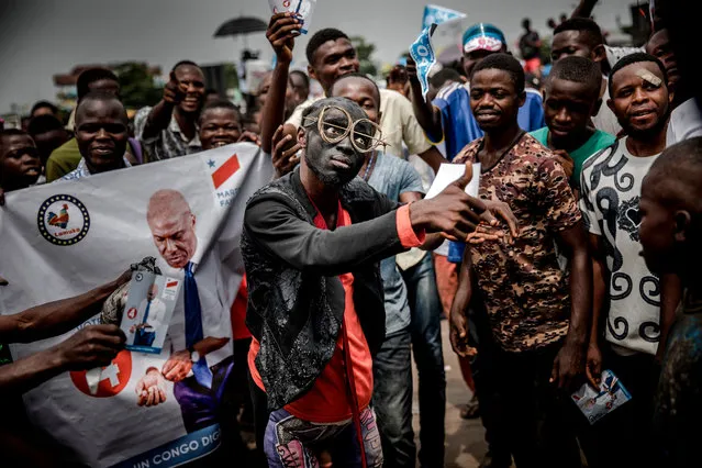 Supporters of opposition leader Martin Fayulu sing and dance as they march and chant slogans in the streets of the Ndjili district of Kinshasa on December 19, 2018, ahead of a campaign rally for Democratic Republic of Congo's general elections. Democratic Republic of Congo goes to the polls on December 23, 2018 in elections which could see the country emerge from 17 years of conflict-ridden rule under the incumbent controversial president. (Photo by Luis Tato/AFP Photo)