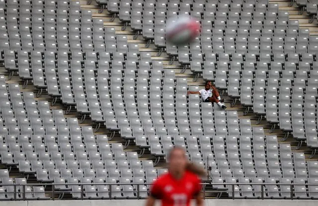 A spectator wearing a protective face mask sits in the empty stadium during the bronze medal match between Fiji and Britain in the women's rugby sevens at the Tokyo Stadium on the eighth day of the Tokyo 2020 Olympic Games in Japan on Saturday, July 31, 2021. (Photo by Stoyan Nenov/Reuters)