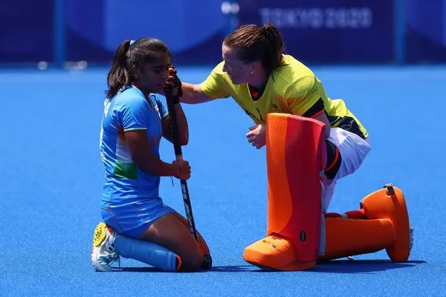 Neha Goyal of India is consoled by Madeleine Hinch of Britain after their women's bronze medal match of the Tokyo 2020 Olympic Games field hockey competition by defeating India 4-3, at the Oi Hockey Stadium in Tokyo, on August 6, 2021. (Photo by Bernadett Szabo/Reuters)