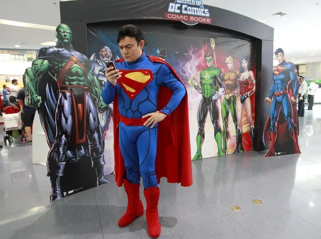 A participant wearing a Superman costume checks his mobile phone before joining the World DC Comics Super Heroes gathering in Manila April 18, 2015. (Photo by Romeo Ranoco/Reuters)