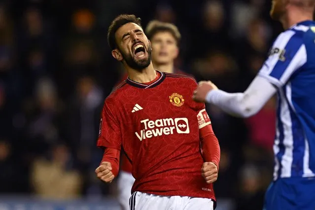 Manchester United's Portuguese midfielder #08 Bruno Fernandes celebrates after scoring their second goal from the penalty spot during the English FA Cup third round football match between Wigan Athletic and Manchester United at the DW Stadium in Wigan, north-west England on January 8, 2024. (Photo by Paul Ellis/AFP Photo)