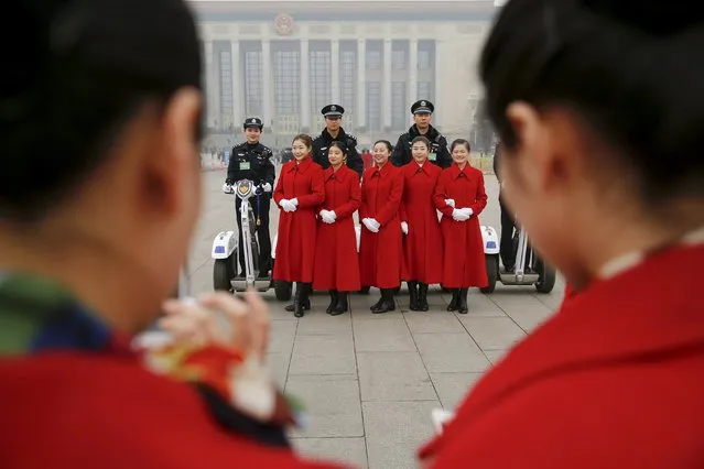 Hostesses pose for pictures with policemen securing the area around the Great Hall of the People during meetings ahead of tomorrow's opening ceremony of the National People's Congress (NPC), in Beijing, China March 4, 2016. (Photo by Damir Sagolj/Reuters)