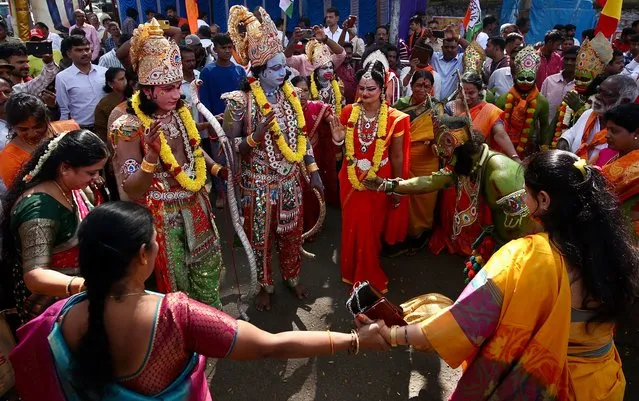 Hindu devotees dance to the local tunes surrounded by Indian folk artist attired like Rama, Sita, Laxmana and Hanuman characters from the India epic “Ramayana” during Pran Pratistha or the inaugural ceremony of the Lord Ram Temple in Ayodhya, held in Bangalore, India, 22 January 2024. New Ram Lalla idol was consecrated at Ayodhya temple during the Pran Pratistha ceremony, or the inauguration. Pran Pratistha is the act which transforms an idol into a deity, giving it the capacity to accept prayers, which was performed by Indian Prime Minister Narendra Modi. (Photo by Jagadeesh N.V./EPA/EFE/Rex Features/Shutterstock)