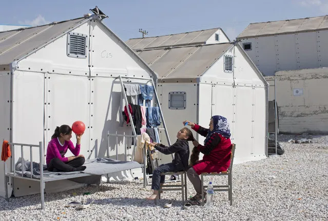 A girl has her hair brushed at the Diavata refugee relocation centre near Thessaloniki on March 07, 2016 in Diavata, Greece. Relocation centres around the northern city of Thessaloniki are continuing to home many refugees though remain largely empty as people push north conscious of the prospect of the border closing permanently. Doctors are warning that conditions at the Idomeni camp close to the Macedonian border are becoming dangerous for children, with medics dealing with a range of illnesses, including hypothermia. (Photo by Dan Kitwood/Getty Images)