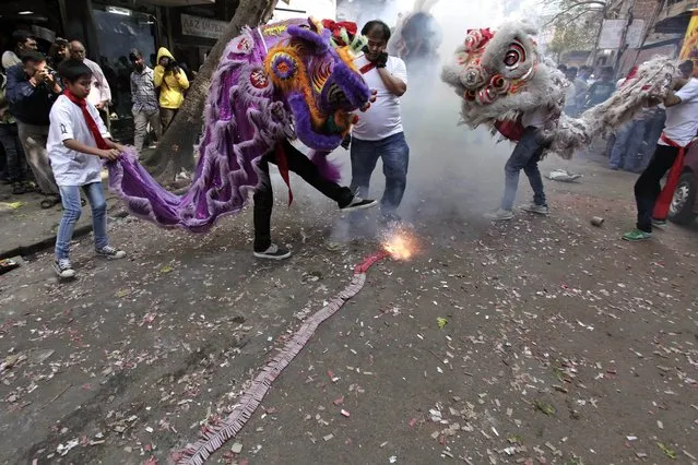 Chinese Lion dancers perform amid exploding fire crackers during Chinese New Year celebrations in Kolkata, India, Friday, January 31, 2014. (Photo by Bikas Das/AP Photo)