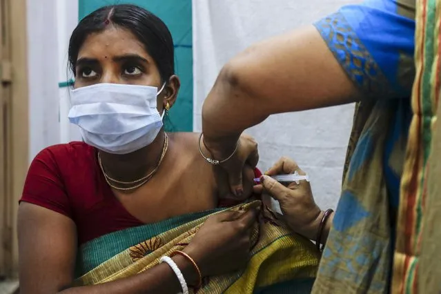 A health worker administers a dose of Covaxin COVID-19 vaccine at a health center in Garia , South 24 Pargana district, India, Thursday, October 21, 2021. India has administered 1 billion doses of COVID-19 vaccine, passing a milestone for the South Asian country where the delta variant fueled its first crushing surge this year. (Photo by Bikas Das/AP Photo)