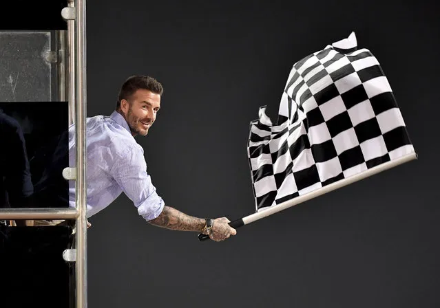Former British football player David Beckham waves the checkered flag as Mercedes driver Lewis Hamilton of Britain crosses the finish line during during the Formula One Bahrain Grand Prix at the Sakhir circuit in Bahrain, Sunday, March 31, 2019. (Photo by Andrej Isakovic/Pool Photo via AP Photo)