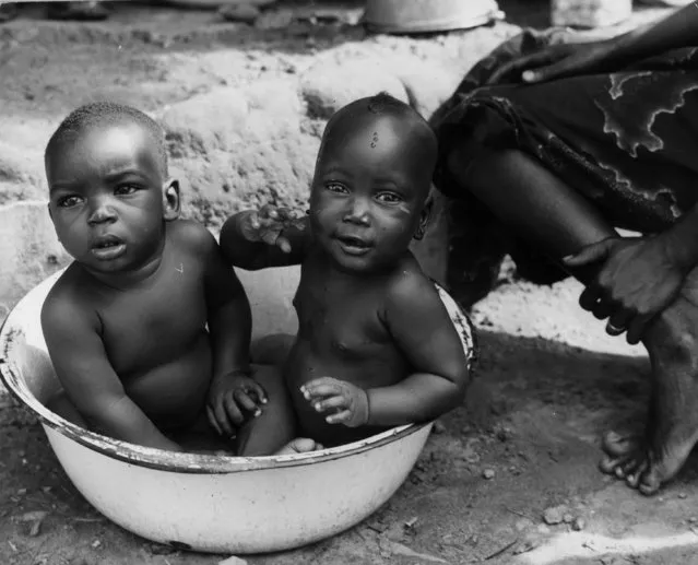 Two children from the west African Republic of Liberia take a bath in a large bowl, circa 1955. (Photo by Three Lions/Getty Images)