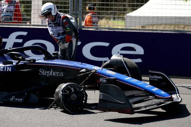 A marshal stays next to Williams' Thai driver Alexander Albon crashed car during the first practice session of the Formula One Australian Grand Prix at the Albert Park Circuit in Melbourne on March 22, 2024. (Photo by Martin Keep/AFP Photo)